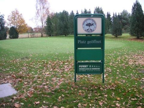 una señal para un parque con un reloj en un campo en Golfhotel Blaue Ente, en Warendorf