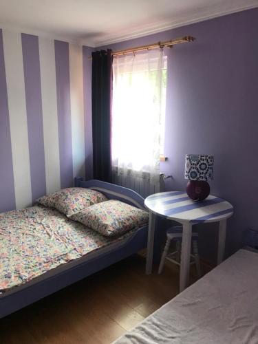 a bedroom with a bed and a table and a window at BaletyuKatany in Białka Tatrzańska