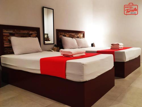 En eller flere senger på et rom på Hotel Turista