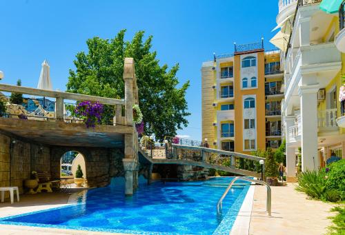 a swimming pool with a bridge and some buildings at Sweet Homes Apartments in Sunny Beach