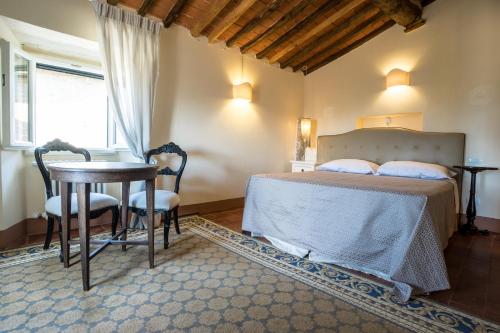 a bedroom with a bed and a table and chairs at Hotel Villa Sermolli in Borgo a Buggiano