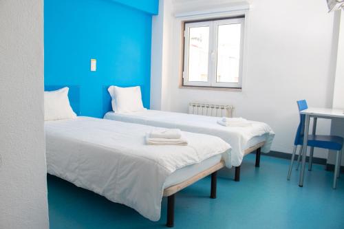 two beds in a room with blue walls at HI Lisboa - Pousada de Juventude in Lisbon
