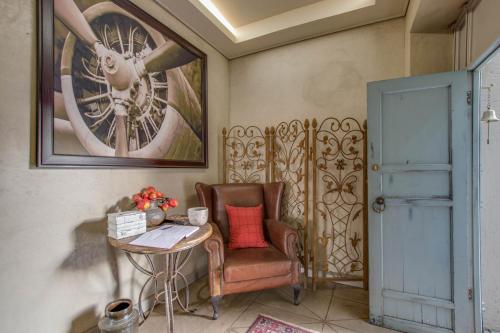 a room with a chair and a table and a picture at Migdash Guesthouse in Hartbeespoort