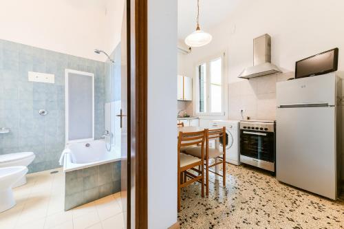 a kitchen with a white refrigerator and a table at La Bauta in Venice