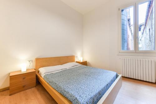 a white bedroom with a bed and a window at La Bauta in Venice