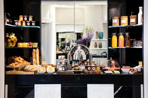 a bakery counter with a variety of bread and pastries at Hôtel Bourgogne & Montana in Paris