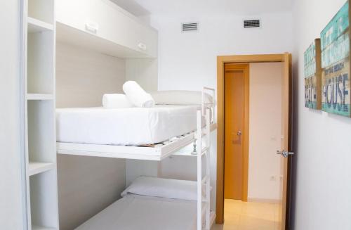 a room with white bunk beds and a doorway at Domatsea Salou Paradise in Salou