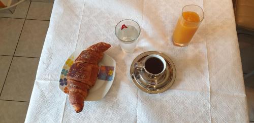 a table with a plate of food and a glass of orange juice at Alexia's Apartments in Rio