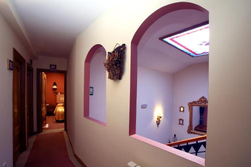 a hallway with arches and a window in a room at Hotel Arco San Vicente in Avila
