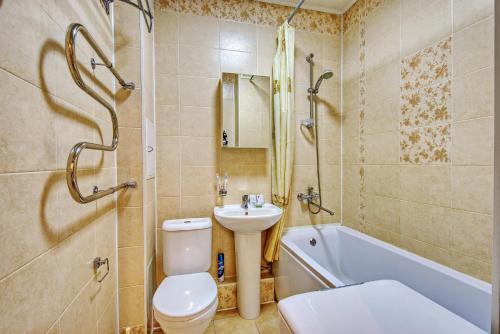 a bathroom with a toilet and a sink and a bath tub at Apartment near the President's Park. Orbita-2 in Almaty