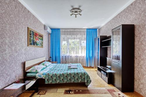 a bedroom with a bed and a television in it at Apartment near the President's Park. Orbita-2 in Almaty