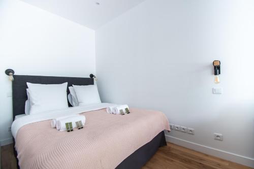 une chambre avec un lit avec deux serviettes dessus dans l'établissement Dreamyflat - Bastille, à Paris