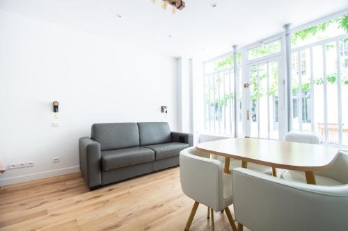 un salon avec un canapé et une table dans l'établissement Dreamyflat - Bastille, à Paris