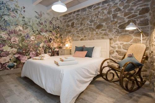 um quarto com uma cama grande e uma parede de pedra em Dulcelia Bilbao. Relax y confort en la ría .EBI-873 em Bilbau