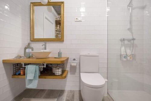 a bathroom with a toilet and a sink and a mirror at Dulcelia Bilbao. Relax y confort en la ría .EBI-873 in Bilbao