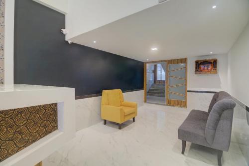 a living room with two chairs and a fireplace at Hotel Palm Beach Pride in Mumbai