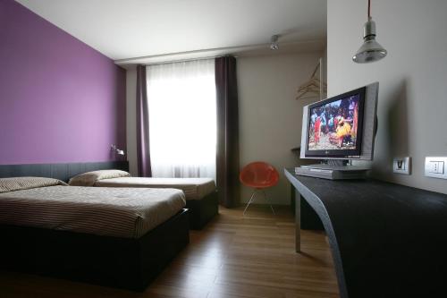 a bedroom with a bed and a television on a desk at Hotel San Francesco in Borgomanero
