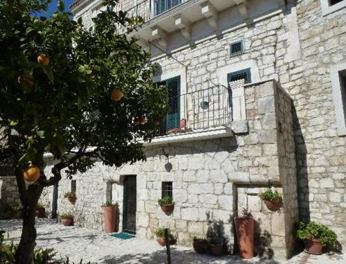 an old stone building with potted plants in front of it at B&B Il Giardino Dei Mandarini in Modica