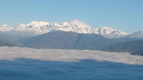 a view of a mountain range with clouds in the foreground at Vamoose Ashis Homestay in Pedong