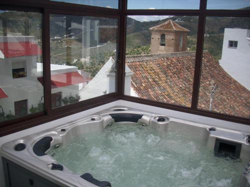 a hot tub in a room with a window at Posada La Plaza in Canillas de Albaida