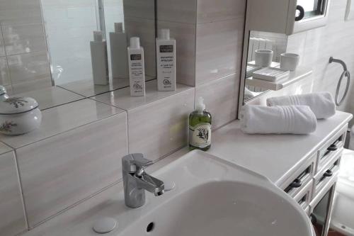 een witte badkamer met een wastafel en een spiegel bij Villa Pancrazzi in Figline Valdarno