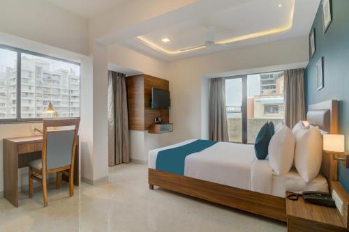 a hotel room with a bed and a desk and a desk at Hotel Palm Beach Pride in Mumbai