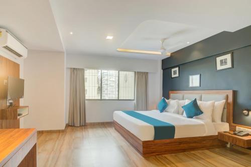 a hotel room with a bed and a television at Hotel Palm Beach Pride in Mumbai