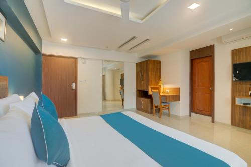 a bedroom with a large bed with blue pillows at Hotel Palm Beach Pride in Mumbai
