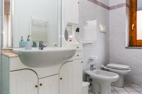 a white bathroom with a sink and a toilet at Terra Mia in Agerola
