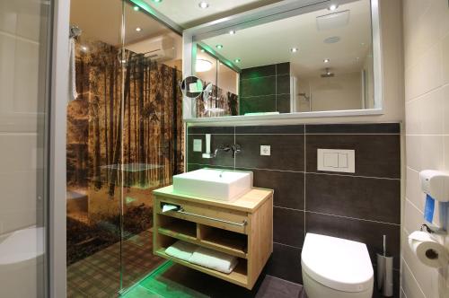 ein Bad mit einem Waschbecken, einem WC und einer Dusche in der Unterkunft Vilstaler Hof Landgasthof & Hotel in Rottersdorf