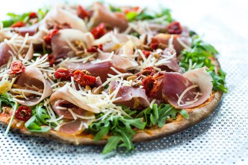 a pizza with ham and greens on a table at DFDS Ferry - Copenhagen to Oslo in Copenhagen
