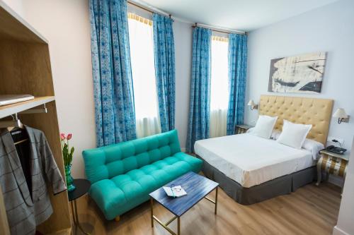 a bedroom with a bed and a couch at Casa de la Merced Suites in Málaga