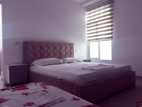 a bedroom with two beds and a window at Eriola apartament in Orikum