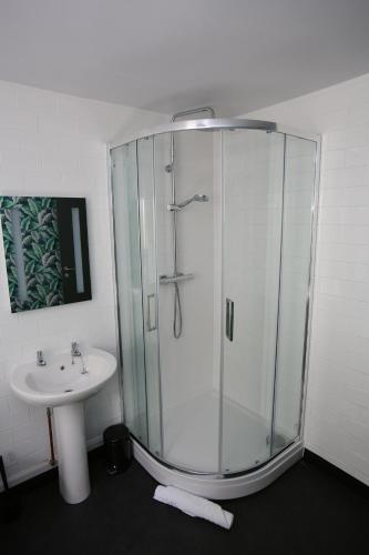a bathroom with a glass shower and a sink at Kings Arms Hotel in Melrose