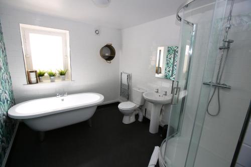 a bathroom with a tub and a sink and a toilet at Kings Arms Hotel in Melrose