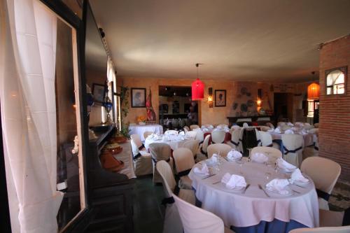 a room full of tables and chairs with white tablecloths at Hotel Copacabana Tarifa Beach in Tarifa
