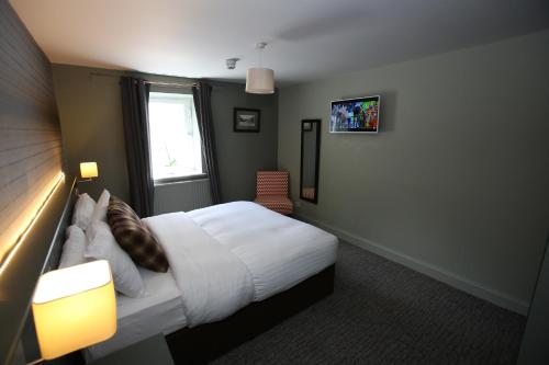 a hotel room with a bed and a window at Kings Arms Hotel in Melrose