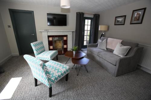 a living room with a couch and chairs and a fireplace at Kings Arms Hotel in Melrose