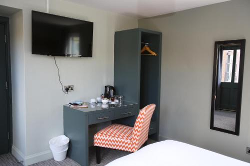 a room with a desk with a chair and a mirror at Kings Arms Hotel in Melrose