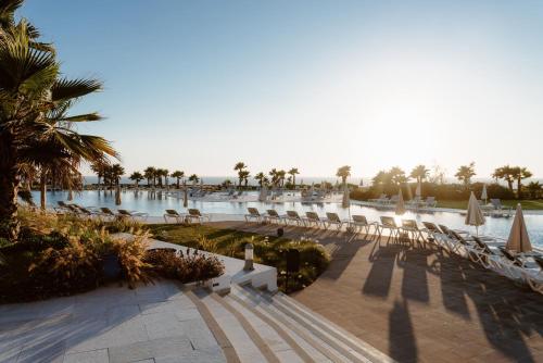 a resort with chairs and a pool and palm trees at Lixus Beach Resort - All In in Larache