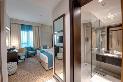 a hotel room with a bathroom and a bedroom at City Avenue Hotel in Dubai