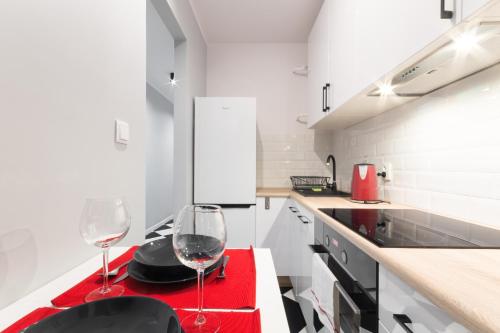 kuchnia z dwoma kieliszkami do wina na czerwonym stole w obiekcie Sea You Apartments- Przytulny w mieście Gdynia