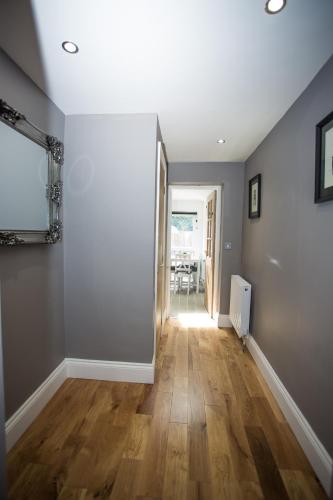 an empty living room with a hard wood floor at Sunset Homes in London