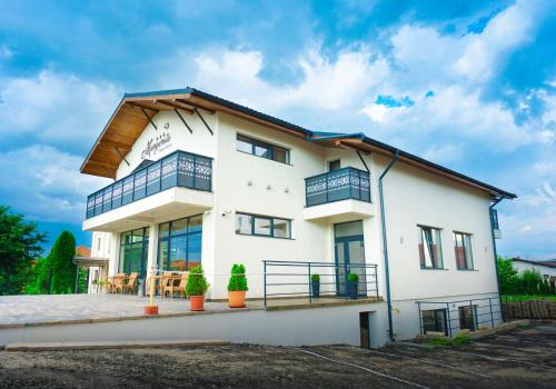 una casa bianca con tetto in legno di Pensiunea Margareta a Alba Iulia