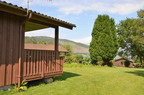 a porch of a house with a tree in the background at Deer Croft Lodge in Hunters Quay