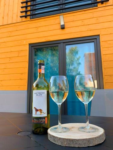 a bottle of wine and two wine glasses on a table at Osada Natura in Śliwin