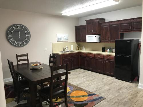 a kitchen with a table and a black refrigerator at Hotel Pensacola in Pensacola