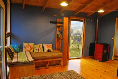 a living room with a couch and a window at Martín Pescador Cabañas in Coihaique