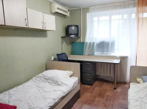 um quarto com uma cama, uma secretária e uma janela em Apartment on Dusi Kovalchuk 272/4 em Novosibirsk