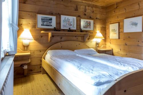 a bedroom with a large bed in a wooden wall at Casa Vesta Magnifica Wildi in Breil/Brigels